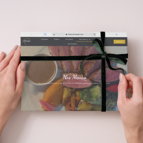 Mockup d’un site web professionnel livré avec un ruban cadeau, symbolisant la livraison finale d’un projet web par Tu Guru en SEO.